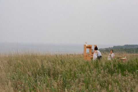 Free Shipping to UAE and Saudi collection with children at a wooden play kitchen in a grassy field