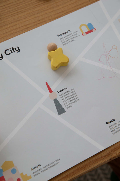 0–2 Years collection with a yellow wooden figure on an illustrated city play map