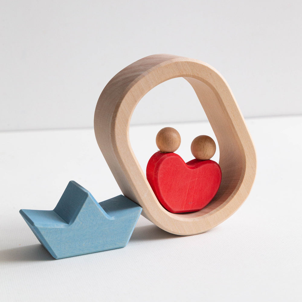 Wooden toy with a boat and heart-shaped house on a white background