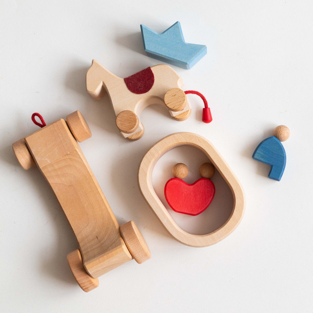 Collection of wooden toys including a horse, car, and house on a white background