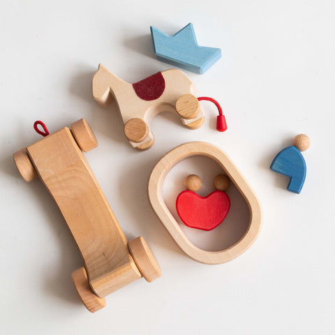 Collection of wooden toys including a horse, car, and house on a white background