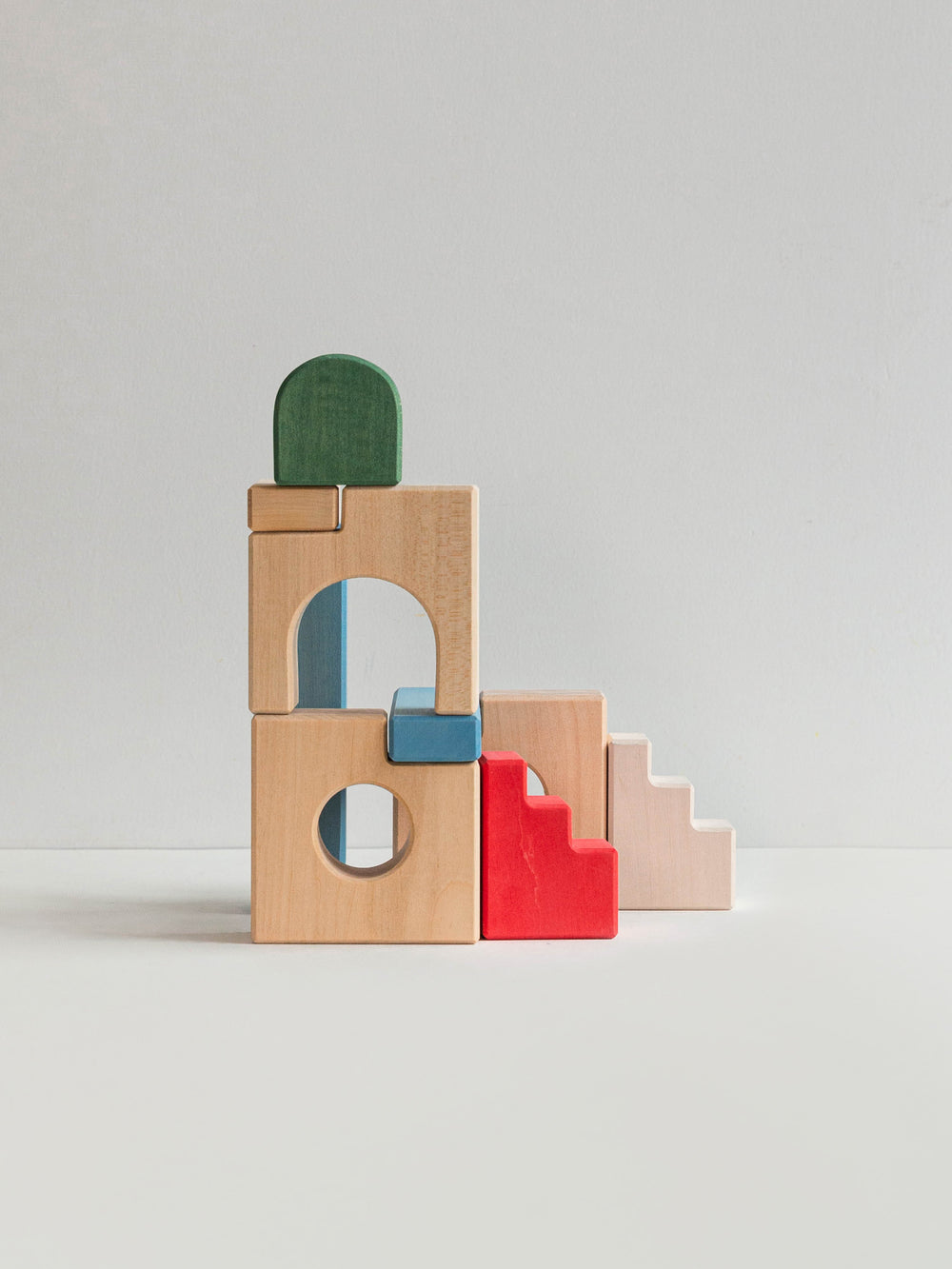 Colorful wooden building blocks and staircase blocks on a light gray background