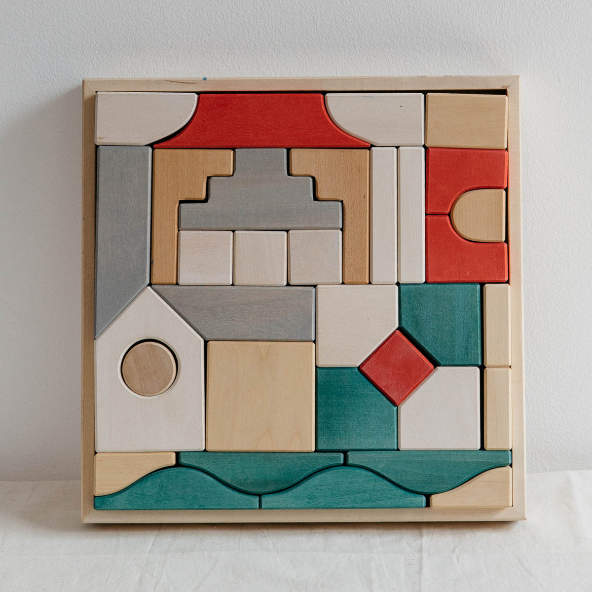 Museum Block Set with red, teal, gray and natural architectural wooden pieces arranged in a square tray
