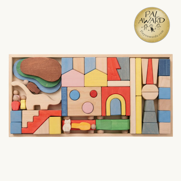 Metropolis Block Set with colorful buildings, trees, vehicles and figures arranged in a wooden tray