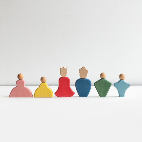 Set of colorful wooden peg dolls on a white background