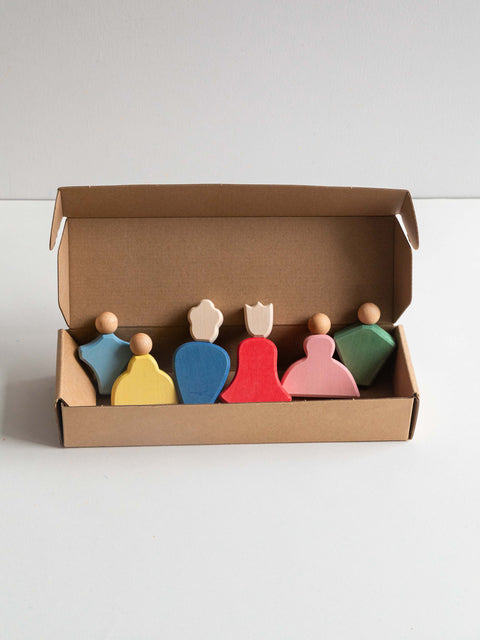 Set of colorful peg dolls in a cardboard box on a white background
