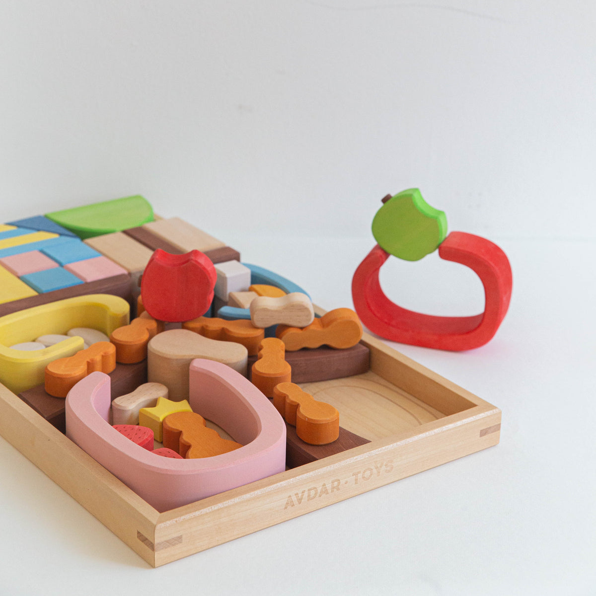 A colorful wooden block set designed to represent an ant house, with various shaped pieces displayed alongside a wooden storage tray.