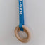 A wooden ring attached to a blue rope with the text 'AVDAR GYM' written on it, hanging against a white background.