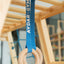 Wooden gymnastic rings with a blue strap hanging on the wooden climber