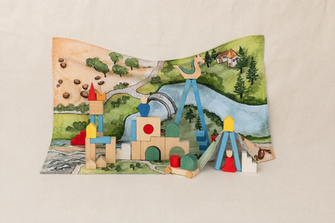 Kingdom Valley play cloth arranged as a backdrop and floor mat with wooden castle blocks