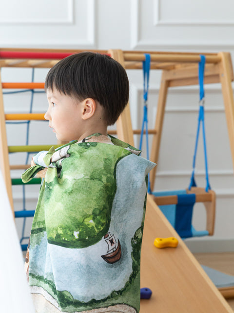 Child wearing the Kingdom Valley play cloth as a cape during imaginative play