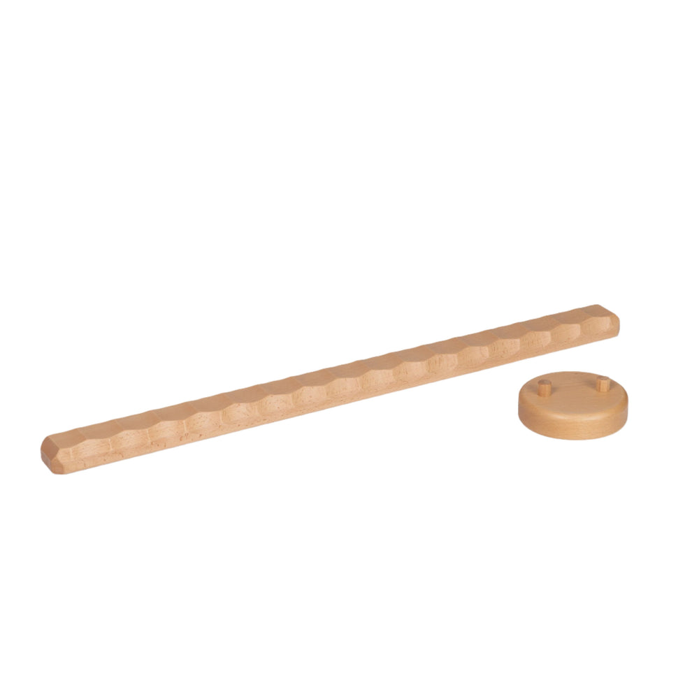 Child's feet on a wooden Naguri Balance Beam with a wavy surface designed for stimulation and massage.