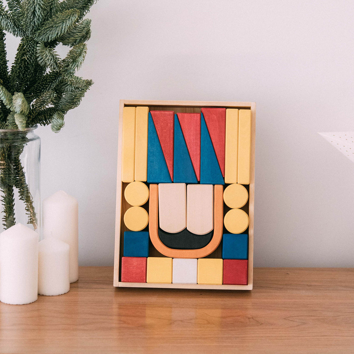 Nutcracker Block Set with red, blue, yellow, black and natural wooden pieces arranged in a rectangular tray