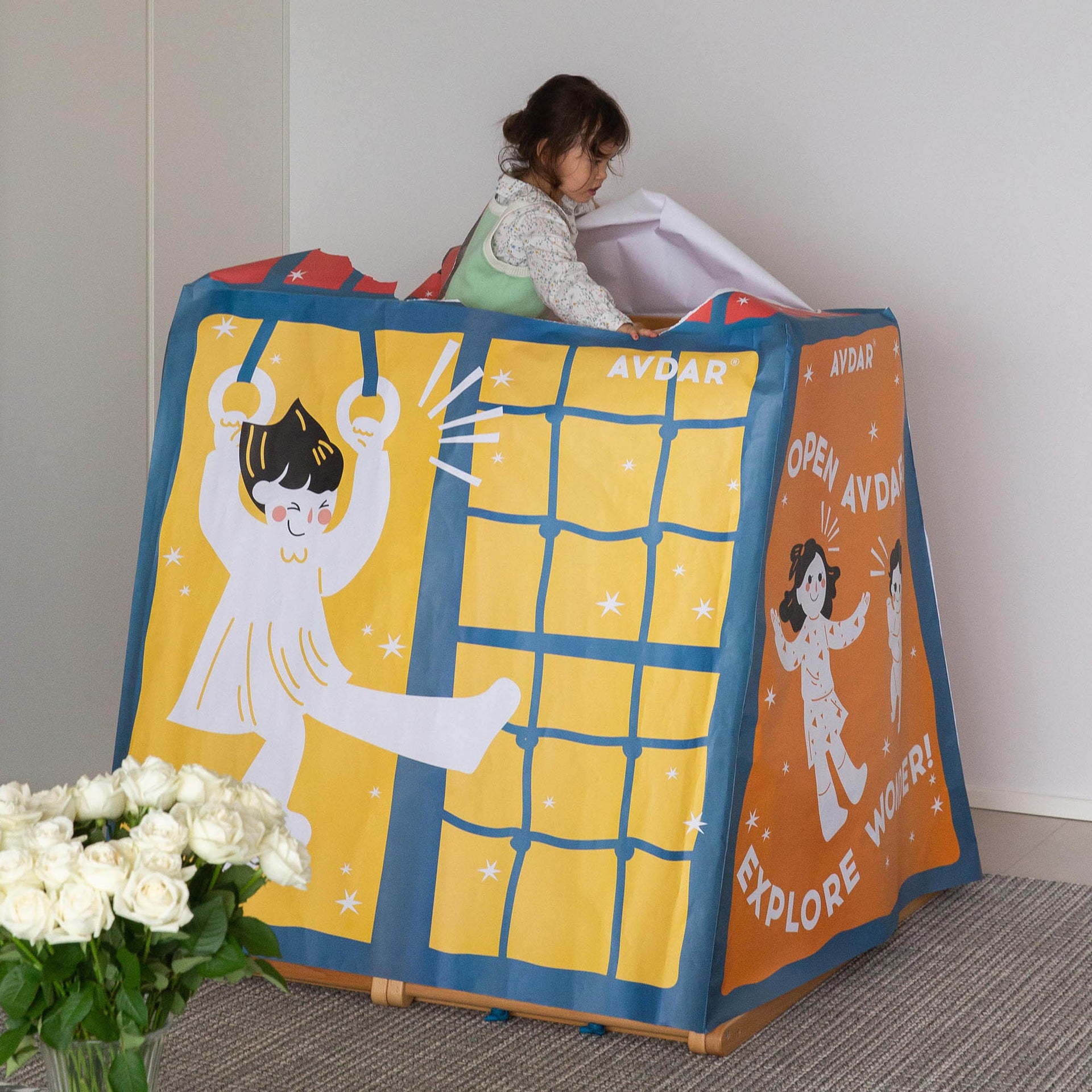 A girl opens the top of the tent with illustrations of a child and text on a white background.