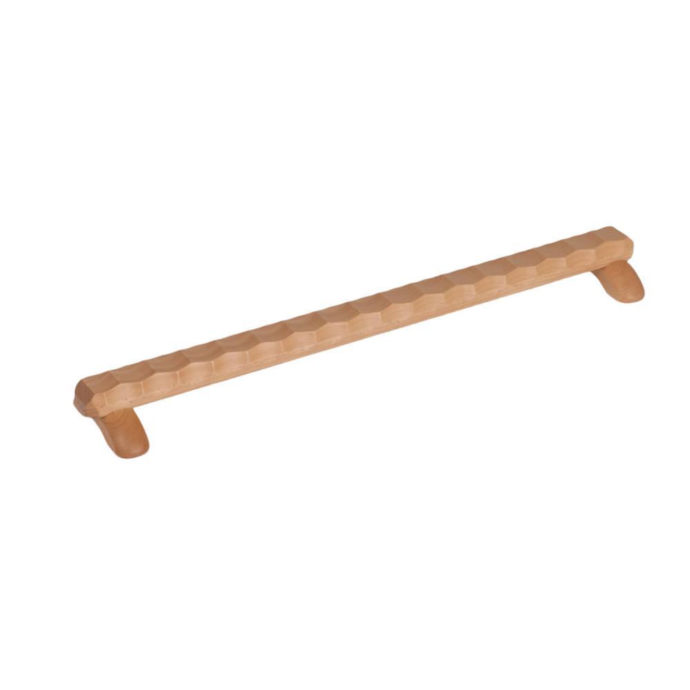Child's feet on a wooden Naguri Balance Beam with a wavy surface designed for stimulation and massage.