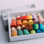 A set of colorful wooden peg dolls and different colored hats.